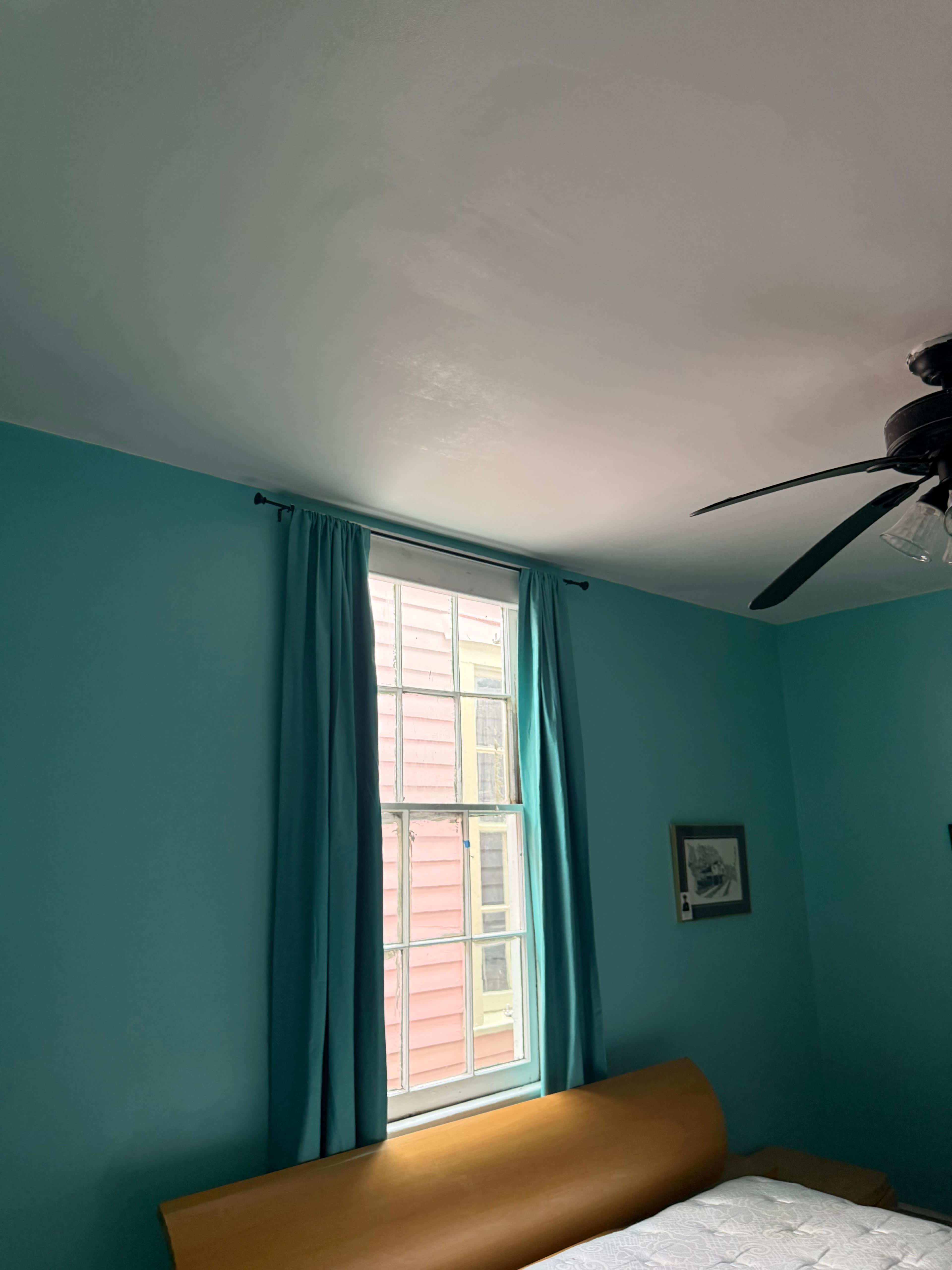 Bedroom after drywall repair and fresh interior painting, teal walls, New Orleans
